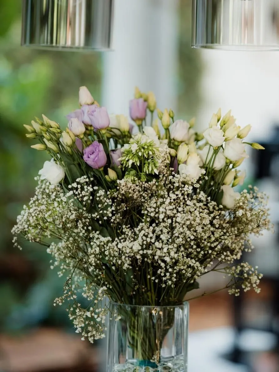 Boeket met paarse lisianthus en gipskruid in een glazen vaas